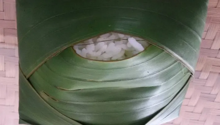 Banana leaf rice with white rice and small portions of curry, dhal, rasam, and papadum arranged on a green leaf