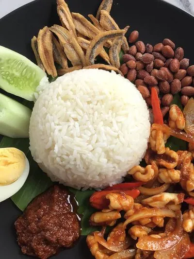 Nasi lemak on a banana leaf with sambal, anchovies, and egg