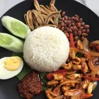 Nasi lemak on a banana leaf with sambal, anchovies, and egg