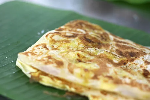 Roti canai flatbread with dhal curry and sambal on the side
